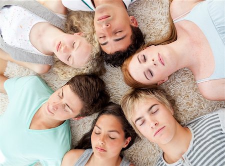 High angle of teenagers with their heads together sleeping on the ground at home Stock Photo - Budget Royalty-Free & Subscription, Code: 400-04200253