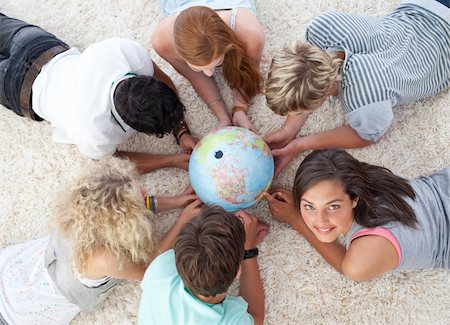 simsearch:400-04200589,k - Group of friends lying on the floor examining a terrestrial world Foto de stock - Super Valor sin royalties y Suscripción, Código: 400-04200286