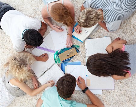 school ground - High angle of teenagers lying on the ground studying together Photographie de stock - Aubaine LD & Abonnement, Code: 400-04200292