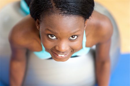 pilates african american - Smiling attractive woman doing push-ups with a gym ball at home Stock Photo - Budget Royalty-Free & Subscription, Code: 400-04200639