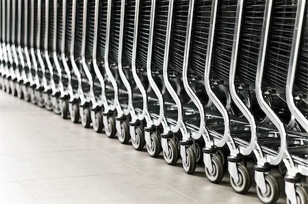 supermarket floor - row of empty shopping carts in the big supermarket (extremely shallow depth of field, focus on fourth wheel from right) Stock Photo - Budget Royalty-Free & Subscription, Code: 400-04200699