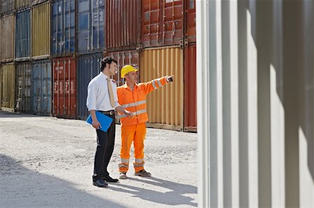 people warehouse freight - mid adult businessman and manual worker standing near cargo containers. Horizontal shape, full length, copy space Foto de stock - Super Valor sin royalties y Suscripción, Código: 400-04201325