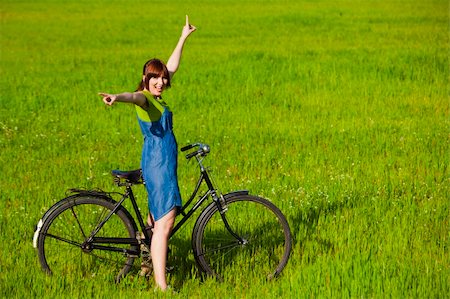 simsearch:400-04201795,k - Happy young woman with a vintage bicycle on a green meadow Fotografie stock - Microstock e Abbonamento, Codice: 400-04201745