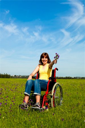 Happy handicapped woman on a wheelchair over a green meadow Stock Photo - Budget Royalty-Free & Subscription, Code: 400-04201787