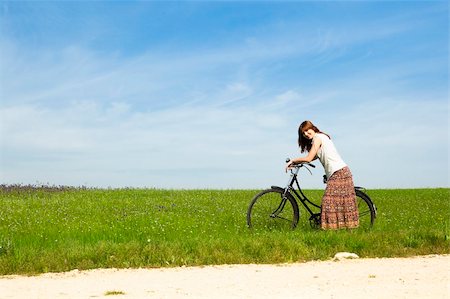 simsearch:400-04201795,k - Happy young woman with a vintage bicycle on a green meadow Fotografie stock - Microstock e Abbonamento, Codice: 400-04201789