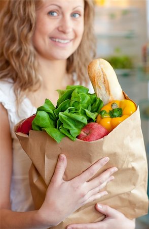 Smiling woman holding a grocery bag in the kitchen Stock Photo - Budget Royalty-Free & Subscription, Code: 400-04202331