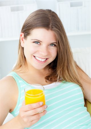 simsearch:400-04708507,k - Charming woman drinking orange juice smiling at the camera Stock Photo - Budget Royalty-Free & Subscription, Code: 400-04202919