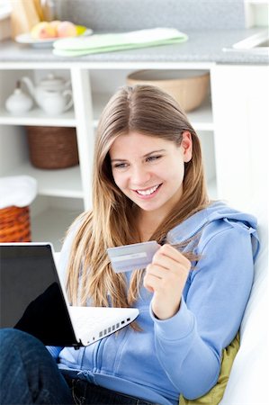 simsearch:6109-06195018,k - Happy woman with a credit card and a laptop in a kitchen Stock Photo - Budget Royalty-Free & Subscription, Code: 400-04202921