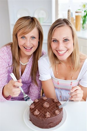 simsearch:400-04212407,k - Happy friends with a cake smiling at the camera  sitting in the kitchen Stock Photo - Budget Royalty-Free & Subscription, Code: 400-04202954