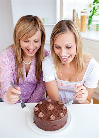 simsearch:400-04729451,k - Glowing friends with a cake sitting in the kitchen Stock Photo - Budget Royalty-Free & Subscription, Code: 400-04202966