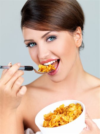 Portrait of beautiful woman, she eating cornflakes Stock Photo - Budget Royalty-Free & Subscription, Code: 400-04214115