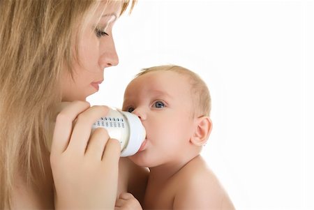 simsearch:400-05382792,k - Mother give drink her baby boy by feeding bottle over white Fotografie stock - Microstock e Abbonamento, Codice: 400-04216904