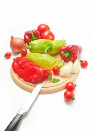 Fresh red and green peppers and onions placed on a wooden cutting board and around arranged with kitchen knife and some cherry tomatoes isolated on white background Stock Photo - Budget Royalty-Free & Subscription, Code: 400-04217198