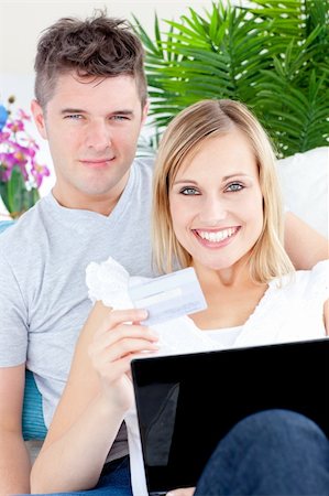 simsearch:400-05741872,k - Enamored couple lying on the sofa with a laptop and a card at home Stockbilder - Microstock & Abonnement, Bildnummer: 400-04217590