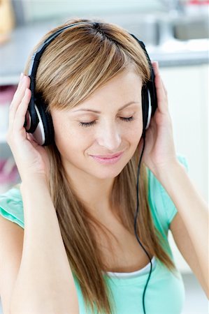 simsearch:400-04207132,k - Young woman listening to music with headphones in the kitchen at home Foto de stock - Super Valor sin royalties y Suscripción, Código: 400-04217657