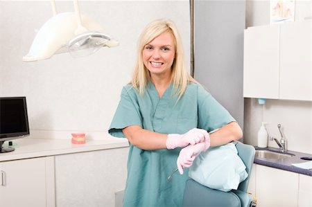 A friendly dentist or dental hygienist standing by a detal chair Stock Photo - Budget Royalty-Free & Subscription, Code: 400-04218078