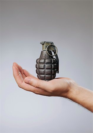 Man holding a hand grenade in his hand Fotografie stock - Microstock e Abbonamento, Codice: 400-04218204