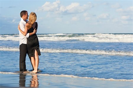 simsearch:400-06751687,k - A young man and woman having fun dancing as a romantic couple on a beach with a bright blue sky Stock Photo - Budget Royalty-Free & Subscription, Code: 400-04219369