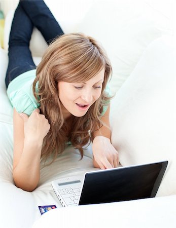 simsearch:400-06419734,k - Joyful blond woman looking at her laptop on the sofa at home Stock Photo - Budget Royalty-Free & Subscription, Code: 400-04210164