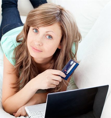 simsearch:400-06419734,k - Close-up of a attractive woman lying ona sofa holding a card and laptop in the living room Stock Photo - Budget Royalty-Free & Subscription, Code: 400-04210160