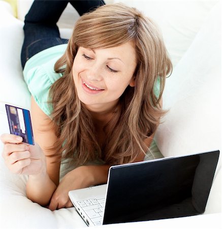 simsearch:400-04709946,k - Lively caucasian woman lying on the sofa with laptop and card in the living room Stockbilder - Microstock & Abonnement, Bildnummer: 400-04210162