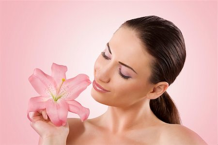 simsearch:400-06137895,k - Fresh portrait of a pretty young woman looking at a pink lily Foto de stock - Super Valor sin royalties y Suscripción, Código: 400-04210467