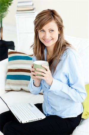 simsearch:400-04188263,k - Captivating blond businesswoman holding a coffee sitting on a sofa using her laptop Foto de stock - Super Valor sin royalties y Suscripción, Código: 400-04210563