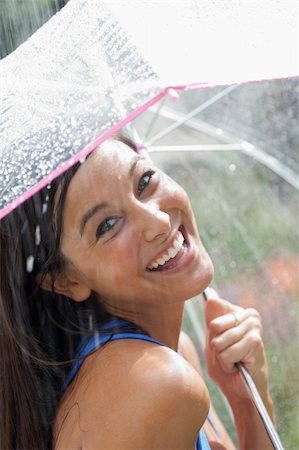 edbockstock (artist) - Beautiful young woman smiles towards the camera while holding an umbrella under a spray of water. Vertical shot. Photographie de stock - Aubaine LD & Abonnement, Code: 400-04211617