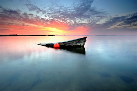 abandoned boat in a bay at sunset Fotografie stock - Microstock e Abbonamento, Codice: 400-04211683