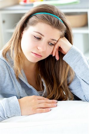 Dejected young woman sitting at the table in the kitchen at home Stock Photo - Budget Royalty-Free & Subscription, Code: 400-04211798