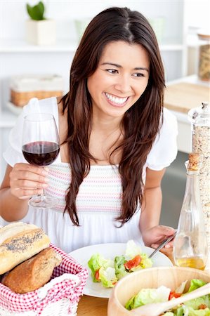 Captivating asian woman holding a wineglass eating a salad at home in the kitchen Stock Photo - Budget Royalty-Free & Subscription, Code: 400-04211812
