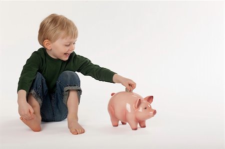 edbockstock (artist) - Cute little boy puts a coin into a piggy bank while sitting on the floor. Horizontal shot. Photographie de stock - Aubaine LD & Abonnement, Code: 400-04212258