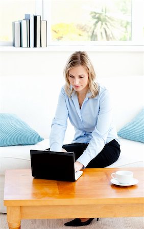 simsearch:400-05741872,k - Glowing businesswoman using her laptop sitting on a sofa at home Stockbilder - Microstock & Abonnement, Bildnummer: 400-04212373
