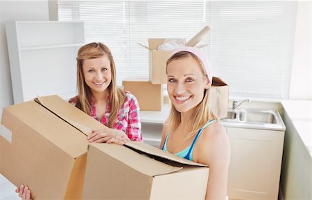 Bright female friends holding boxes after moving Stock Photo - Budget Royalty-Free & Subscription, Code: 400-04212411