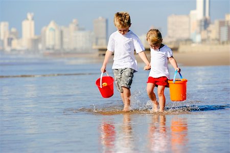 Brother and sister walk along the ocean edge looking for shells Stock Photo - Budget Royalty-Free & Subscription, Code: 400-04212760