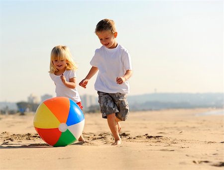 Beautiful brother and sister play with a beach ball outdoors Stock Photo - Budget Royalty-Free & Subscription, Code: 400-04212763