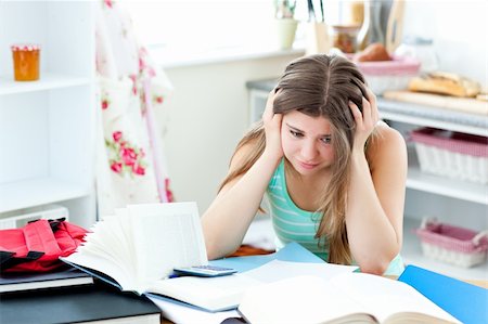 Tired caucasian student doing homework sitting in the kitchen at home Stock Photo - Budget Royalty-Free & Subscription, Code: 400-04212804
