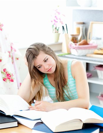 Bored caucasian student doing homework sitting in the kitchen at home Stock Photo - Budget Royalty-Free & Subscription, Code: 400-04212805
