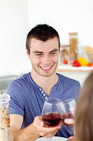 simsearch:400-04212835,k - Handsome young man having diner with his girlfriend drinking wine at home in the kitchen Photographie de stock - Aubaine LD & Abonnement, Code: 400-04212840