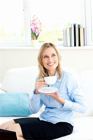 simsearch:400-04187842,k - Smiling businesswoman holding a cup of coffee sitting on a sofa at home Stock Photo - Budget Royalty-Free & Subscription, Code: 400-04212867