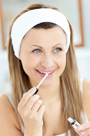 Glowing woman applying gloss on her lips in the bathroom at home Stock Photo - Budget Royalty-Free & Subscription, Code: 400-04213029