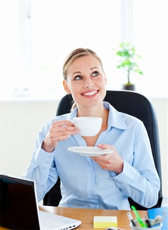 simsearch:400-05741872,k - Delighted businesswoman drinking coffee in front of her laptop in her office at her desk Stockbilder - Microstock & Abonnement, Bildnummer: 400-04213169