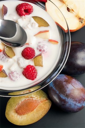 Glass bowl filled with yogurt mixed with fruit pieces arranged with spoon and some fruits around Stock Photo - Budget Royalty-Free & Subscription, Code: 400-04213386