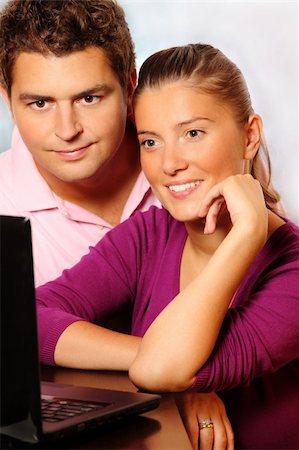 A picture of a young married couple sitting together at home and searching the Internet Stock Photo - Budget Royalty-Free & Subscription, Code: 400-04224142
