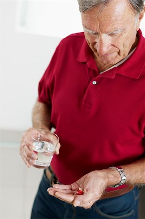 simsearch:400-06106335,k - Senior man holding pills. Vertical shape, side view, waist up Stock Photo - Budget Royalty-Free & Subscription, Code: 400-04224551