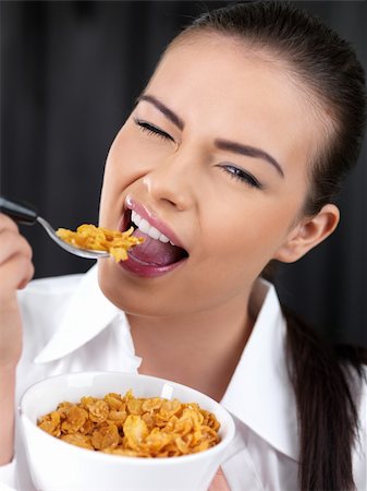 Portrait of beautiful woman, she eating cornflakes Stock Photo - Budget Royalty-Free & Subscription, Code: 400-04224697