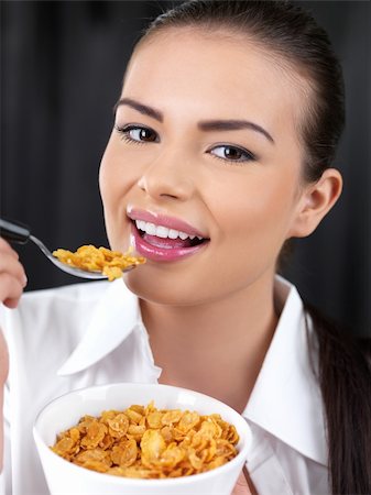 Portrait of beautiful woman, she eating cornflakes Stock Photo - Budget Royalty-Free & Subscription, Code: 400-04224718