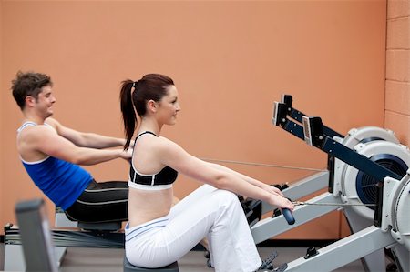 simsearch:400-04256139,k - Young couple using a rower in a sport centre Stock Photo - Budget Royalty-Free & Subscription, Code: 400-04224775