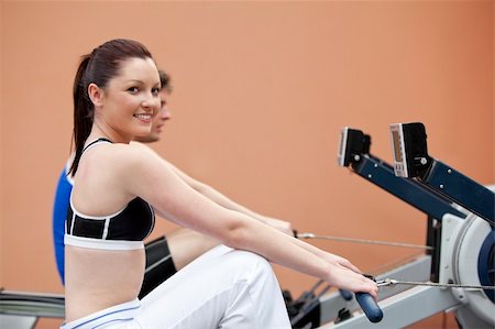 simsearch:400-05677914,k - Happy woman with her boyfriend using a rower in a fitness centre Stock Photo - Budget Royalty-Free & Subscription, Code: 400-04224777