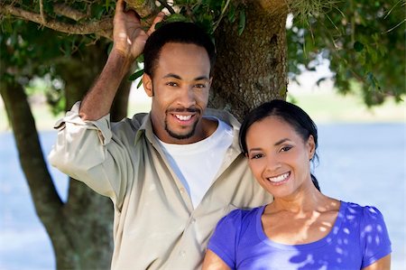 simsearch:400-04655735,k - A happy African American man and woman couple standing outside under a tree. Stockbilder - Microstock & Abonnement, Bildnummer: 400-04224884
